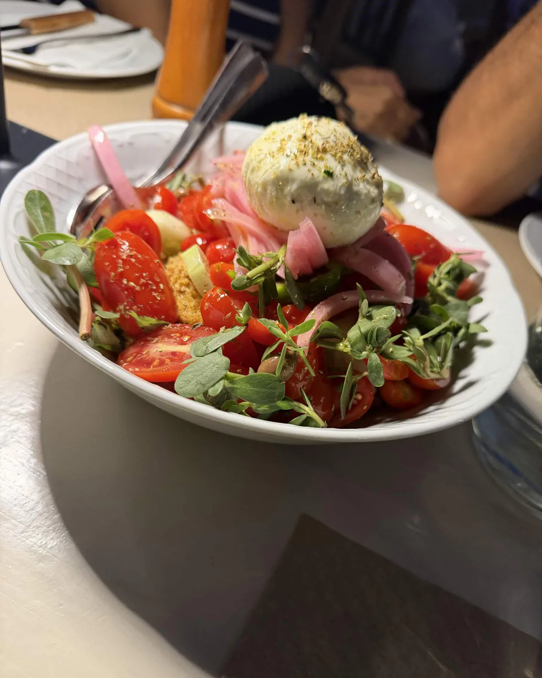 Greek salad with tomatoes, pickled onion, greens and Cretan cheese at Taverna Aloni