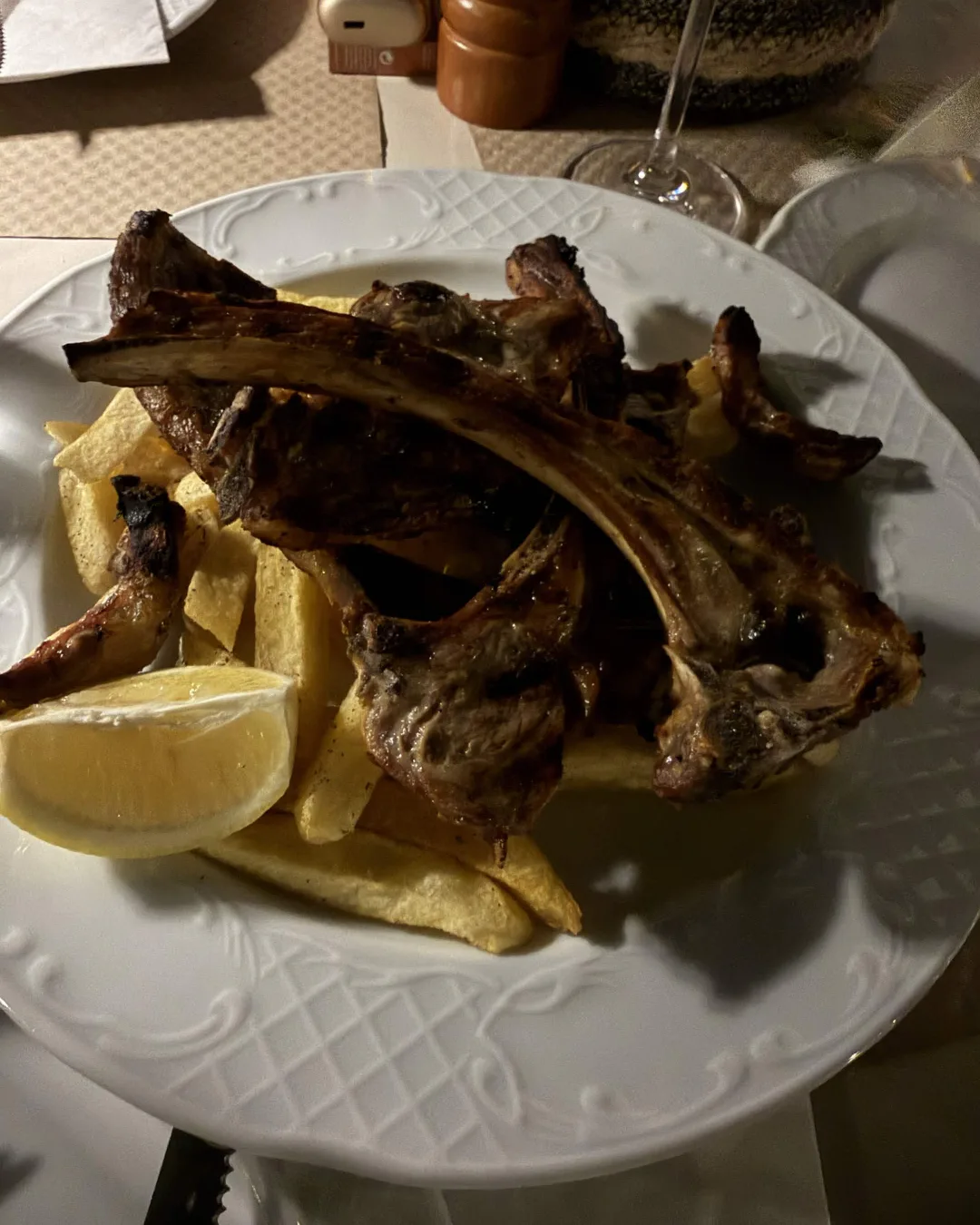 Grilled lamb chops with fried potatoes and lemon at Taverna Aloni
