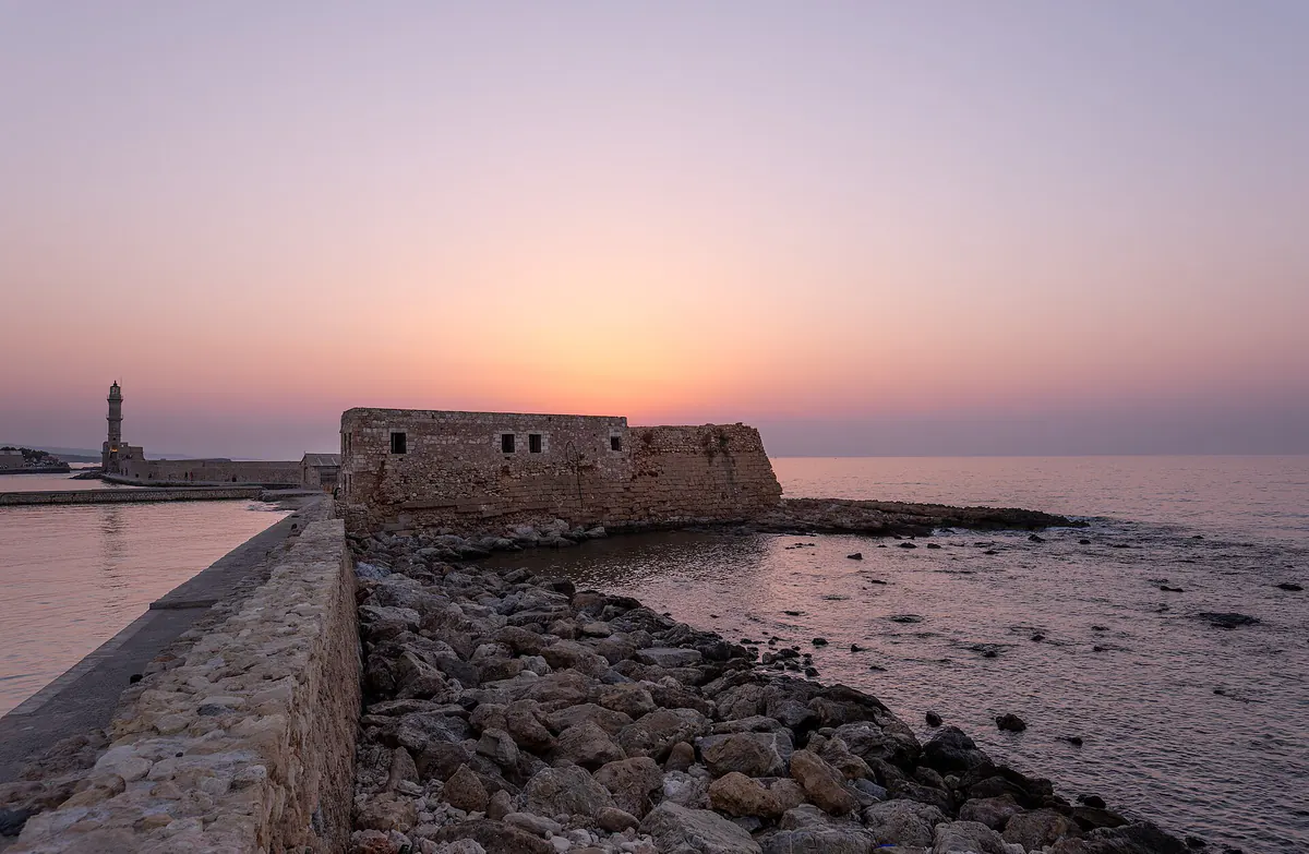 The old Venetian harbor and lighthouse of Chania at sunset