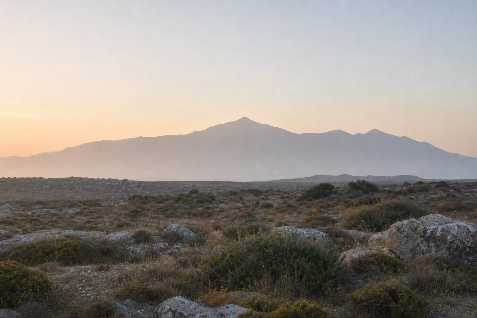 Distant Cretan mountain under dawn light with open rocky ground in the foreground