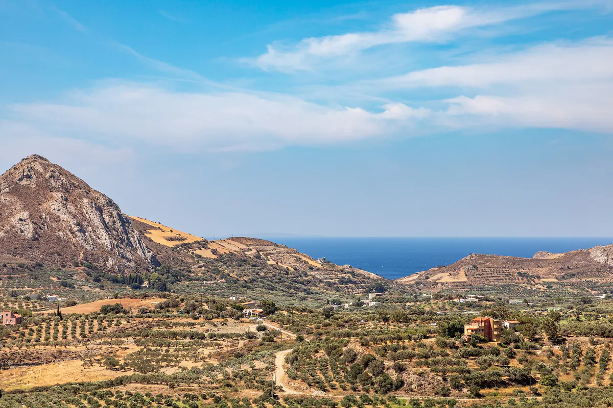 A coastal plain near Asomatos village in Crete, backed by bare limestone mountains that rise sharply from the sea