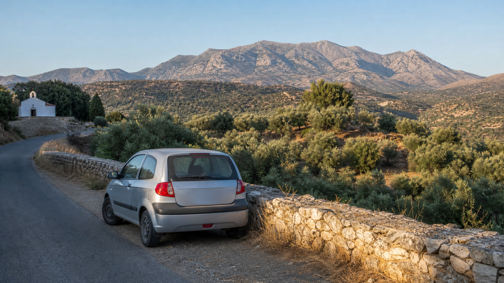 Compact car on a village road in Crete — practical, no logos, not luxury