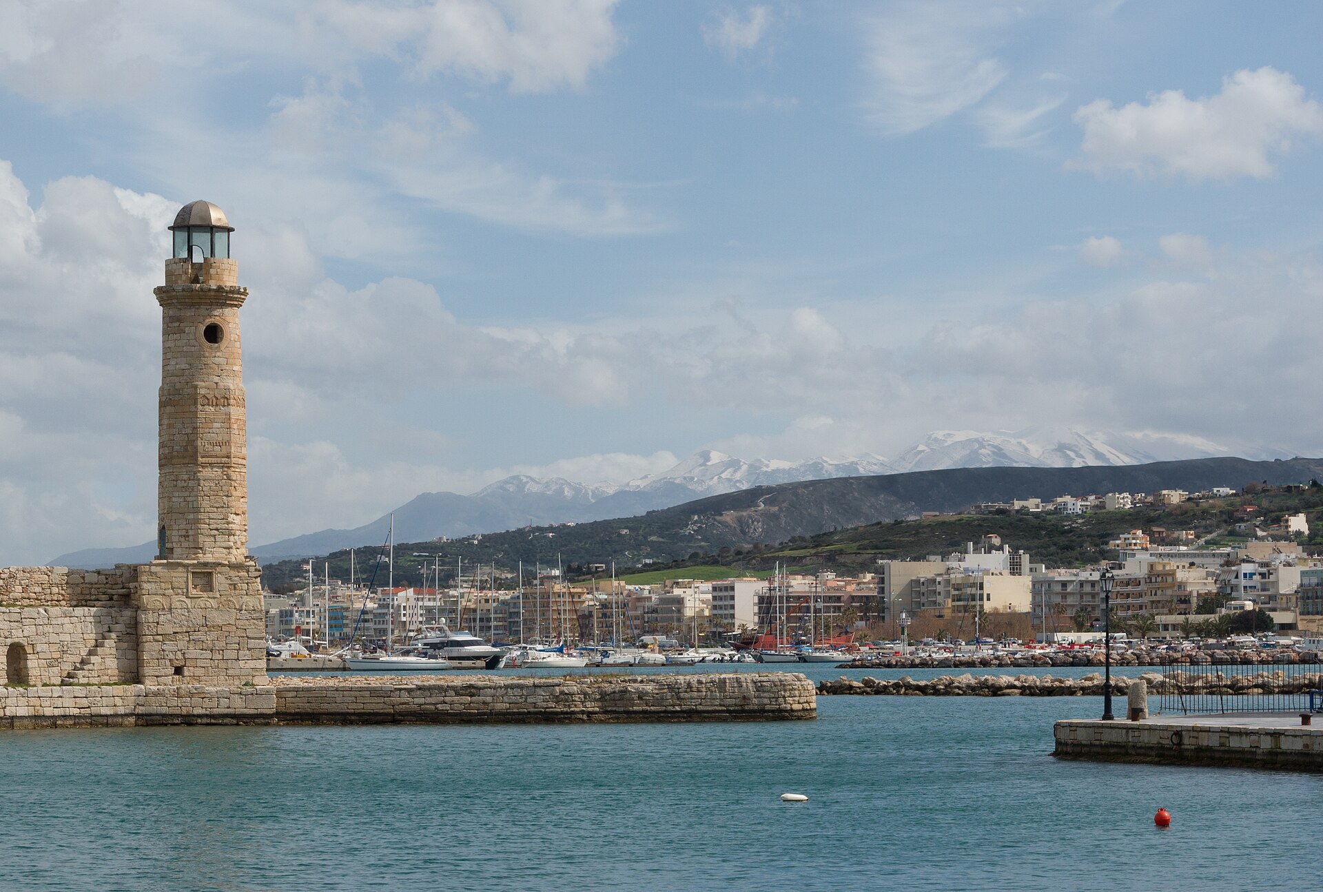 Rethymno harbour in winter with snow covering the mountains rising behind the Cretan coast
