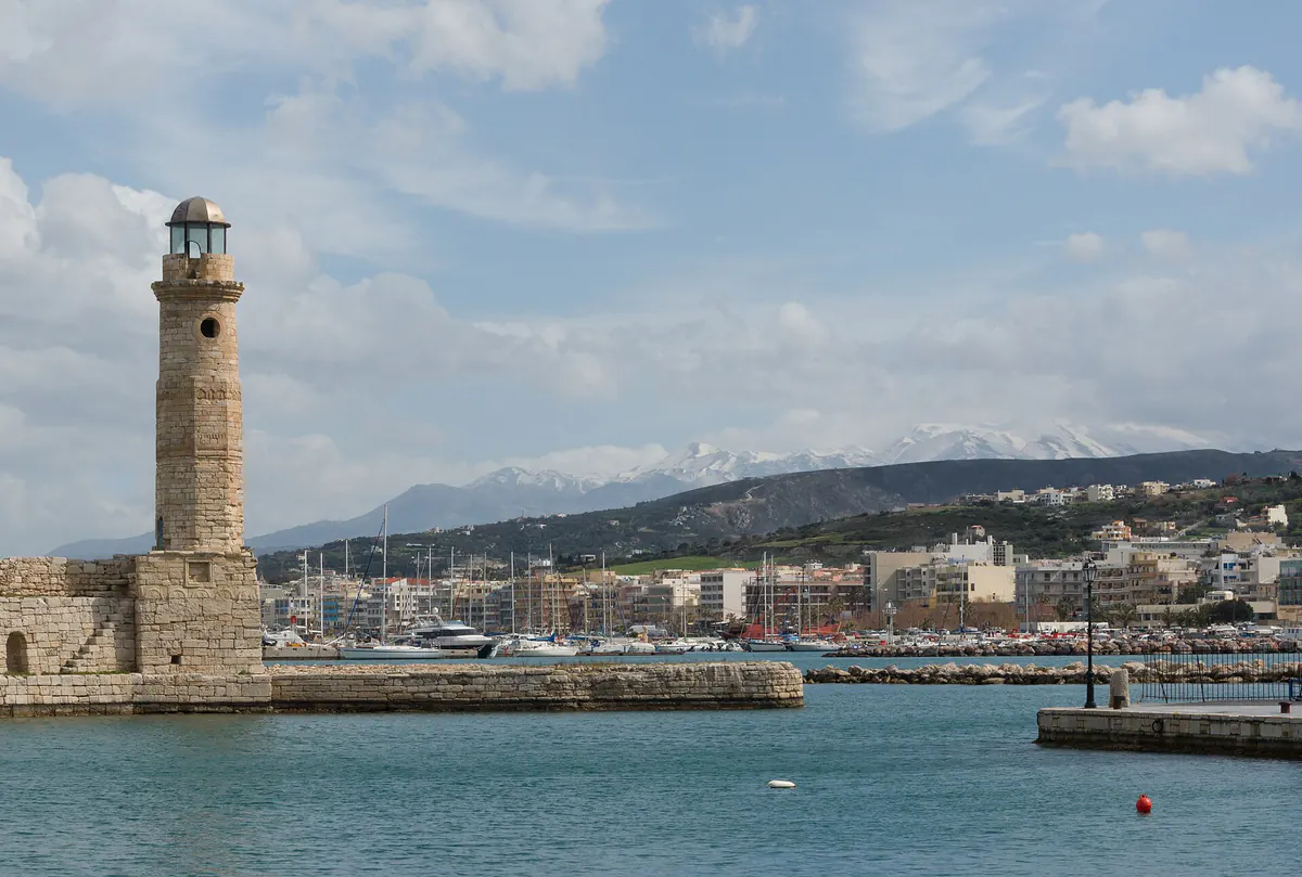 Rethymno harbor in winter with snow covering the mountains rising behind the Cretan coast