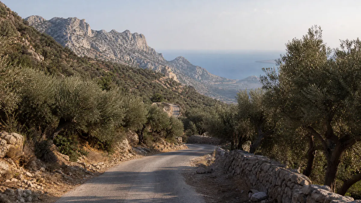 A road curving through the Cretan landscape, mountains ahead, coast in the distance