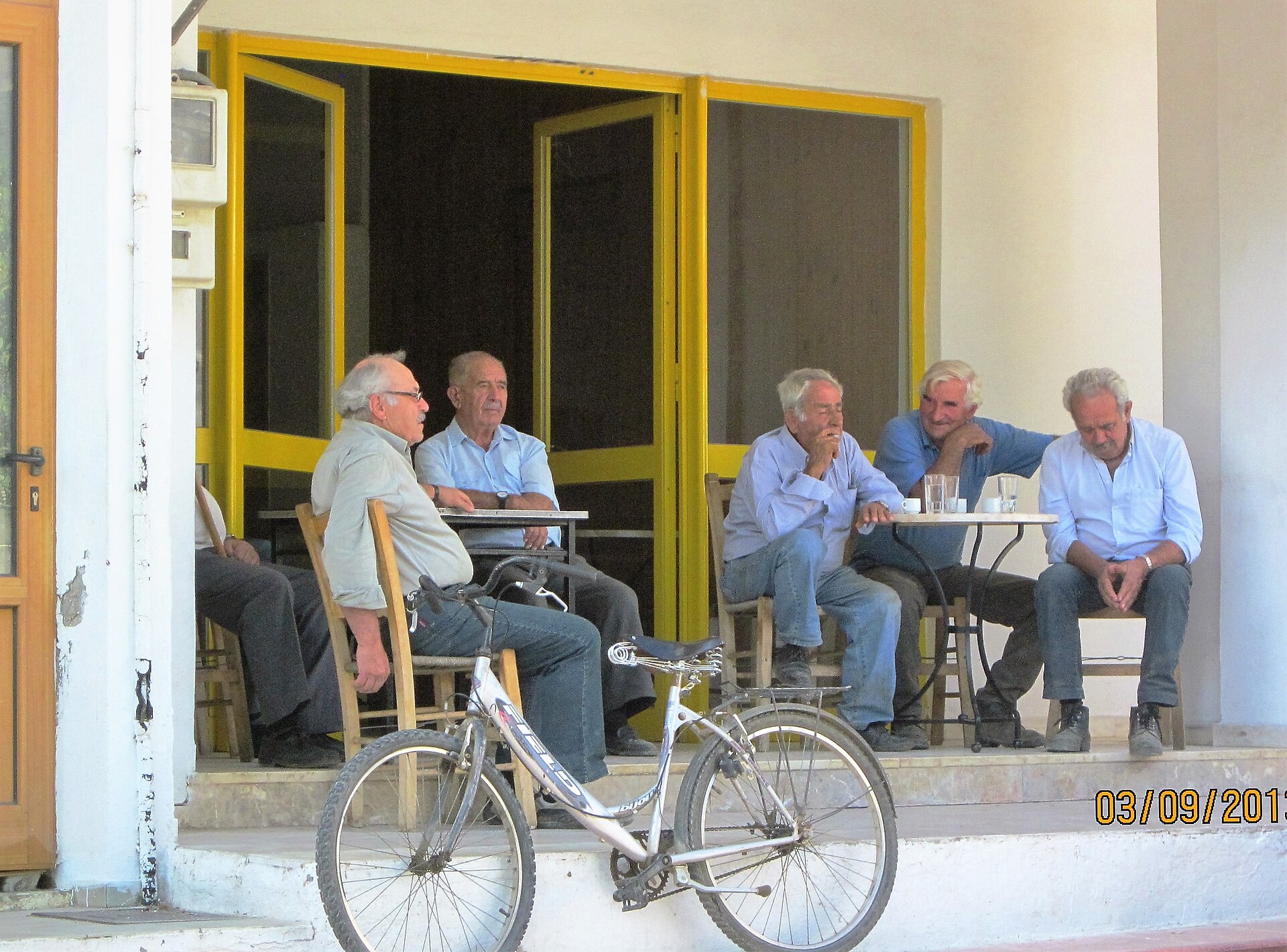 Older men sitting and talking outside a village kafeneio in eastern Crete