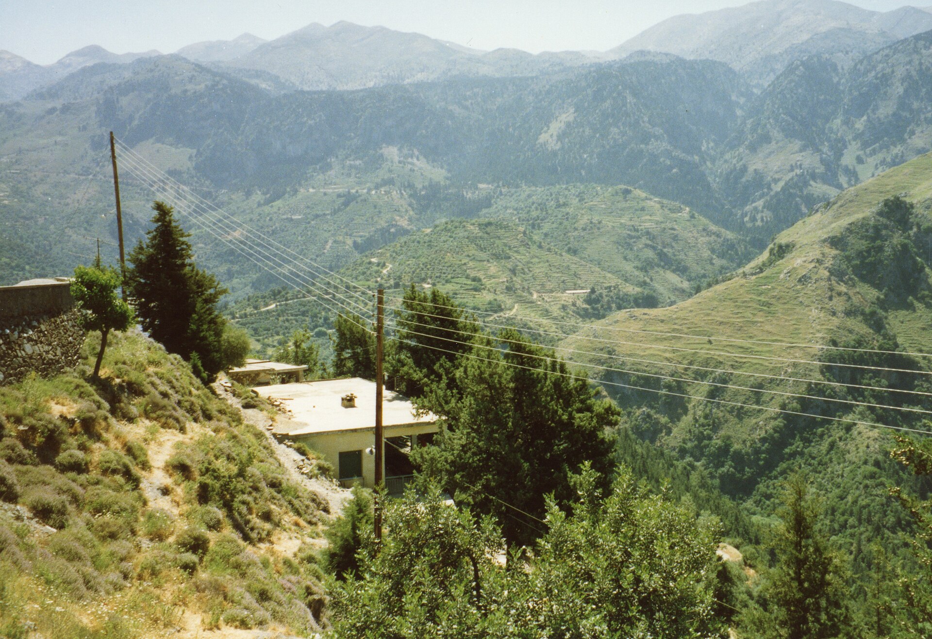 The winding mountain road climbing toward the Samaria Gorge on Crete, switchbacks cut into bare limestone slopes.