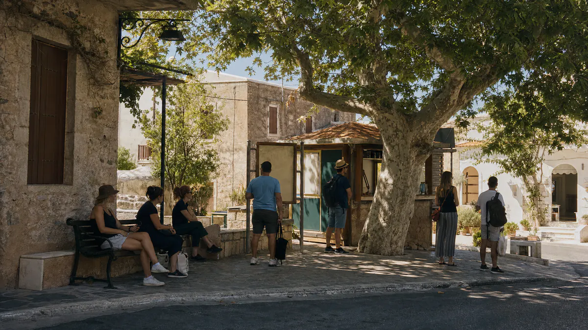 A town-base transport scene representing car-free travel planning in Crete