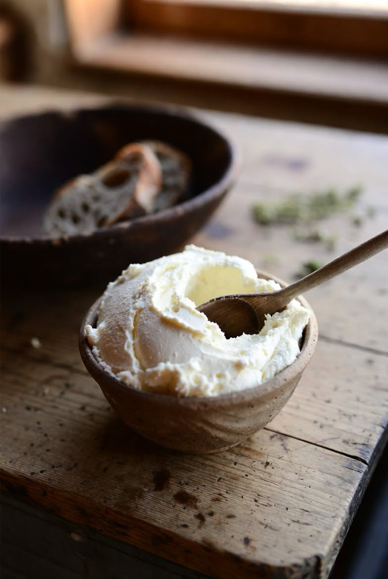 A bowl of staka with a wooden spoon on a rustic table