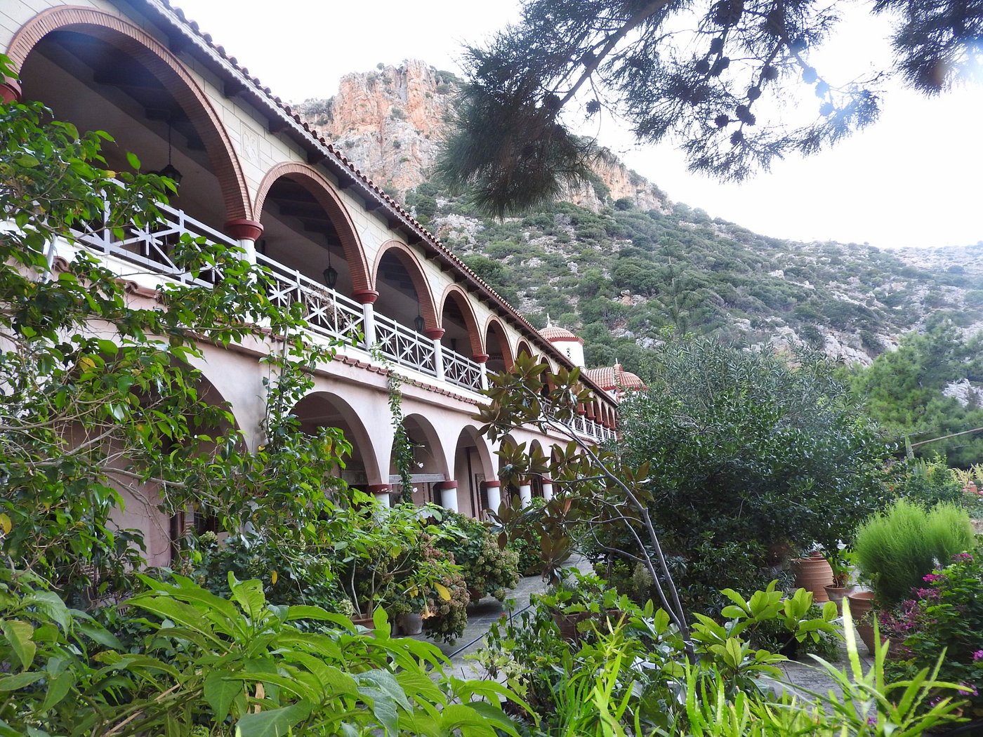 Monastery arcades with lush gardens beneath the rocky hillside